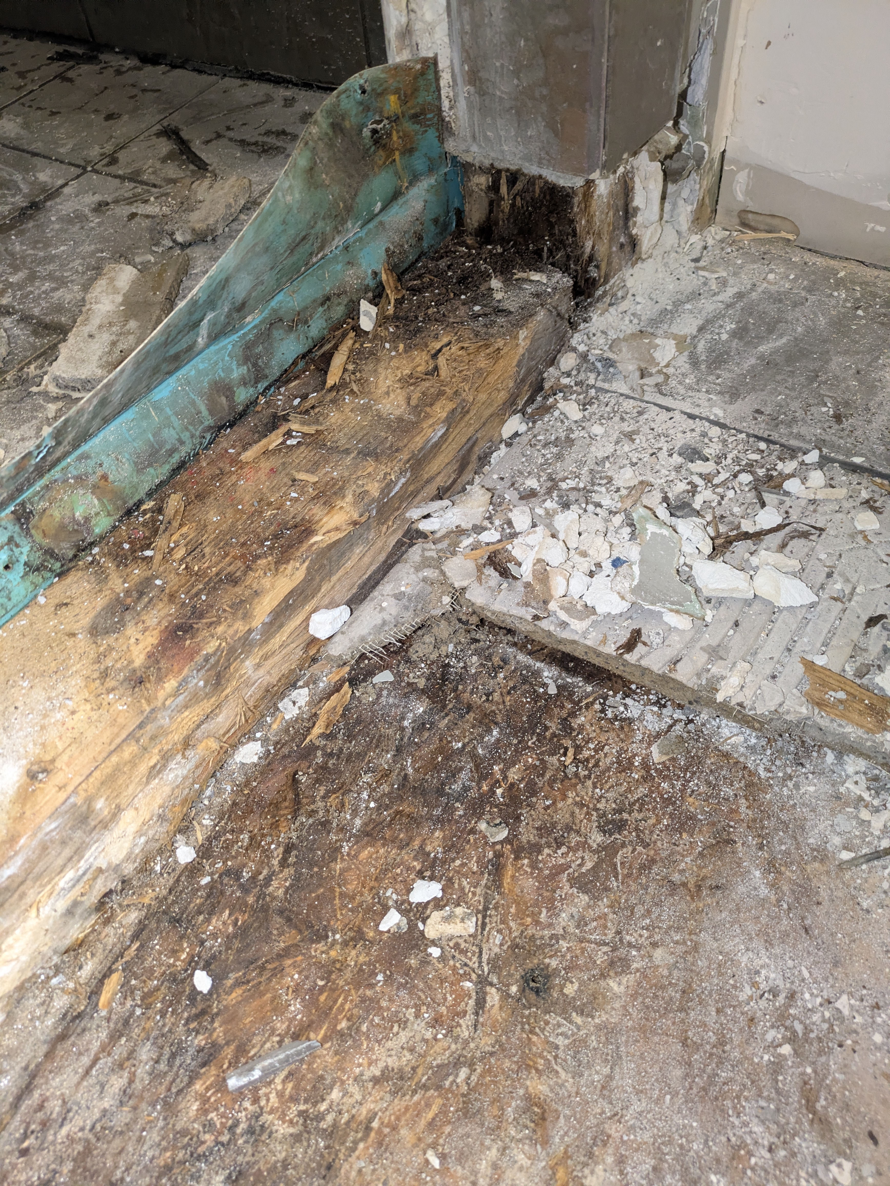Removing water-damaged subfloor layers in a Normaltown bathroom